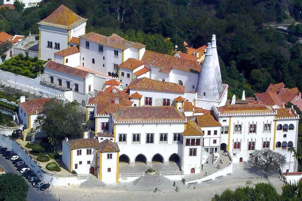 veľká biela budova s červenými strechami a kostolom
