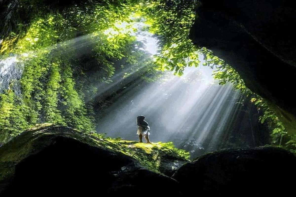 una persona in piedi di fronte a una grotta