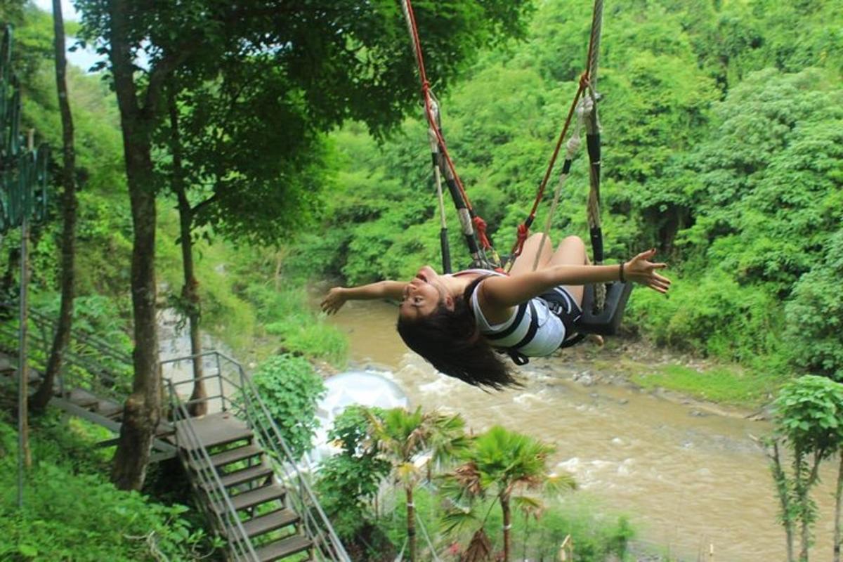 a woman swinging on a rope swing over a river