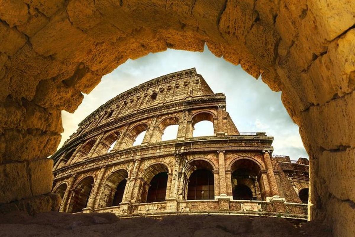 una vista del Colosseo attraverso un arco di pietra