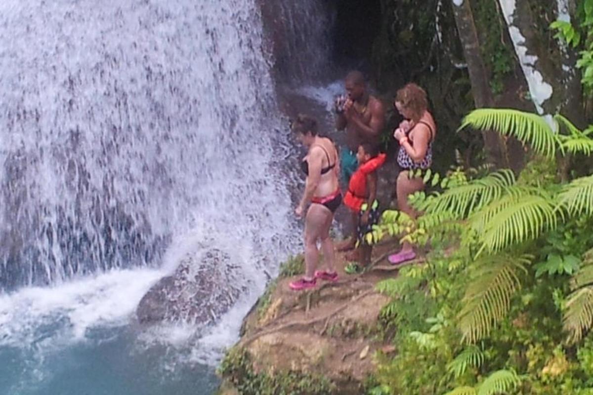 un gruppo di persone in piedi su una roccia vicino a una cascata
