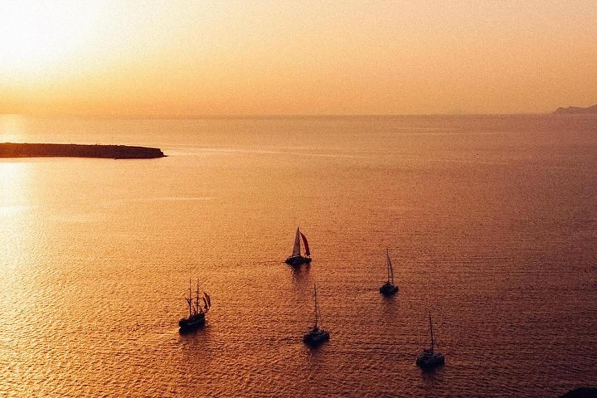 un gruppo di tre barche in acqua al tramonto