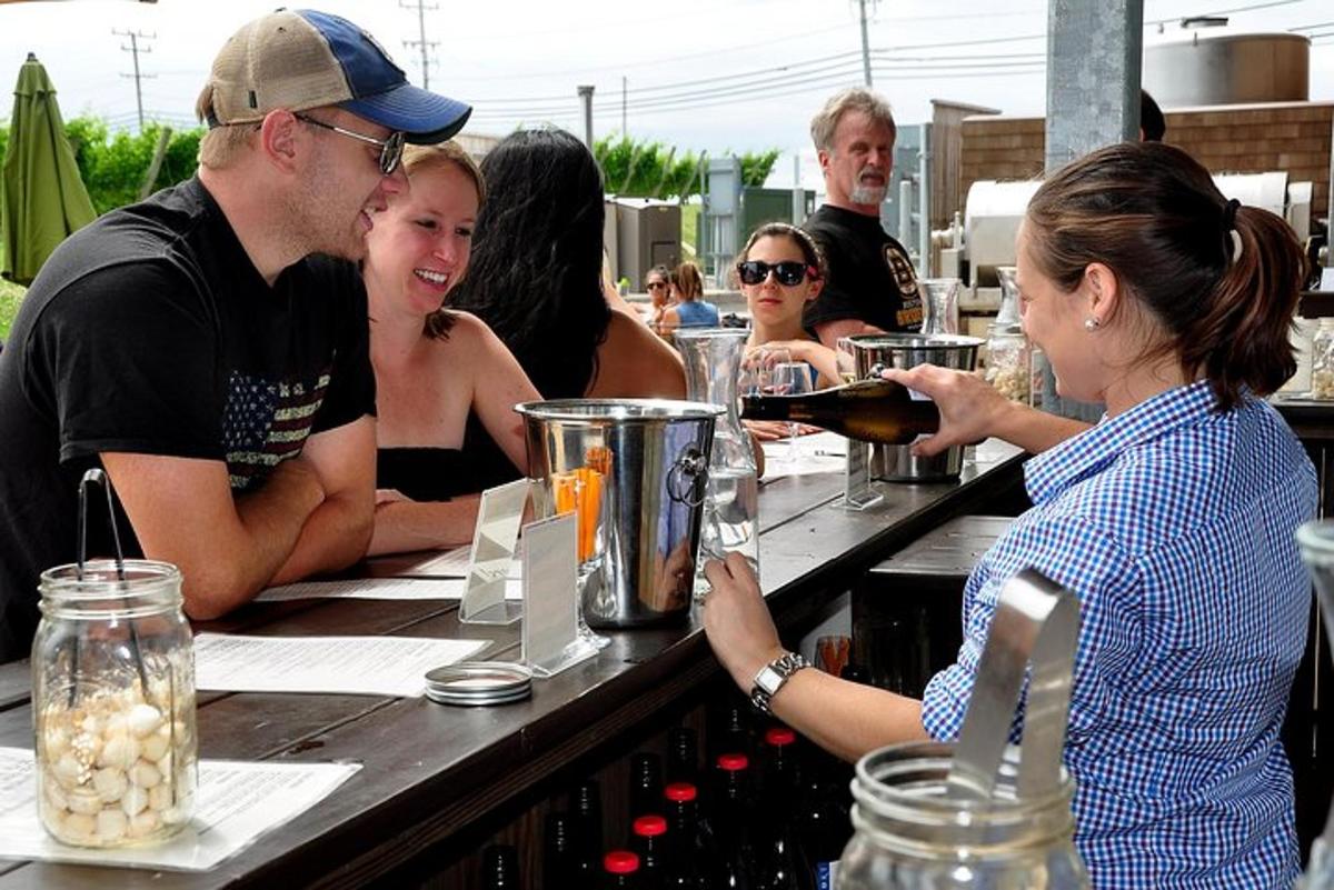 a group of people sitting at a bar drinking wine