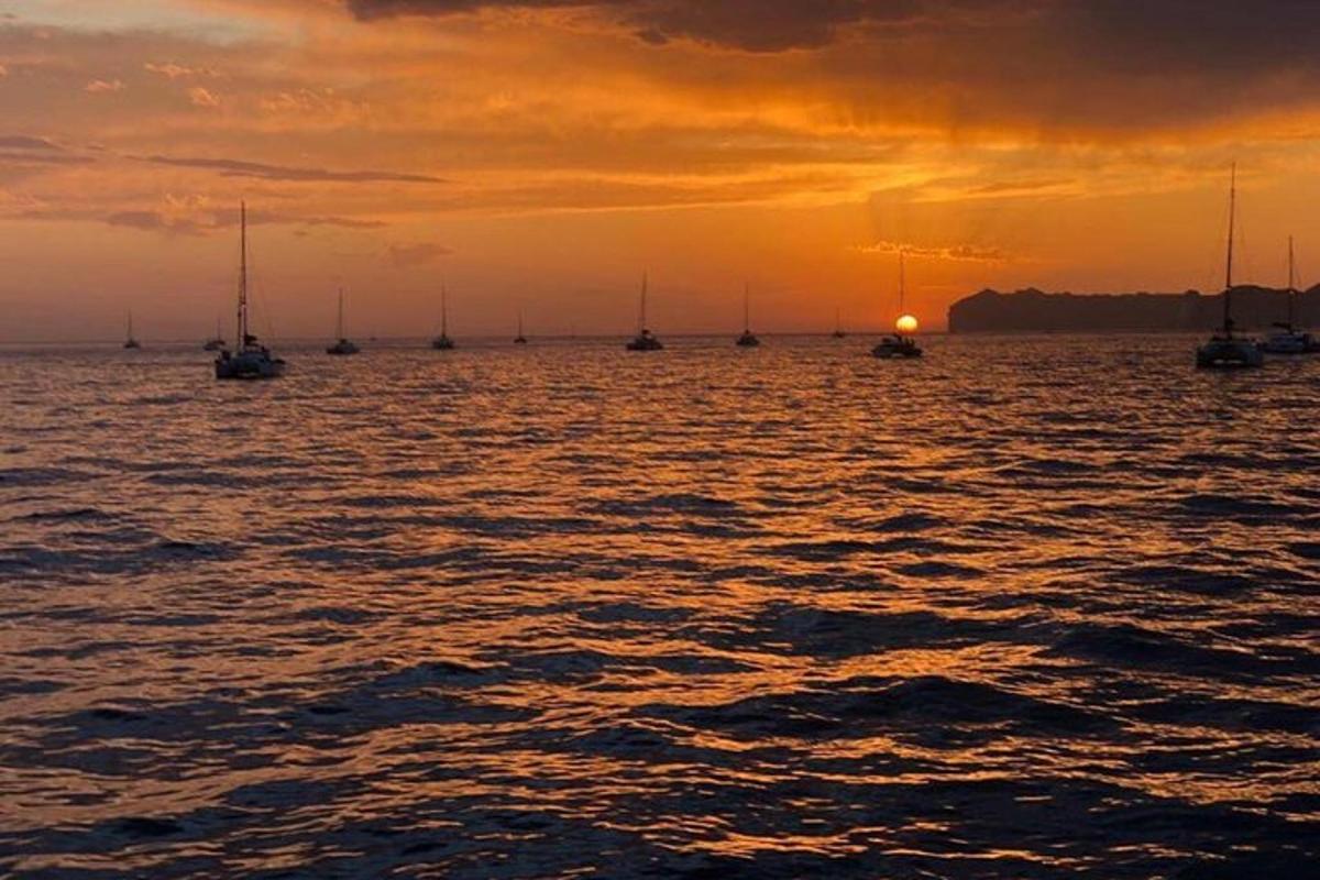 um grupo de barcos na água ao pôr do sol