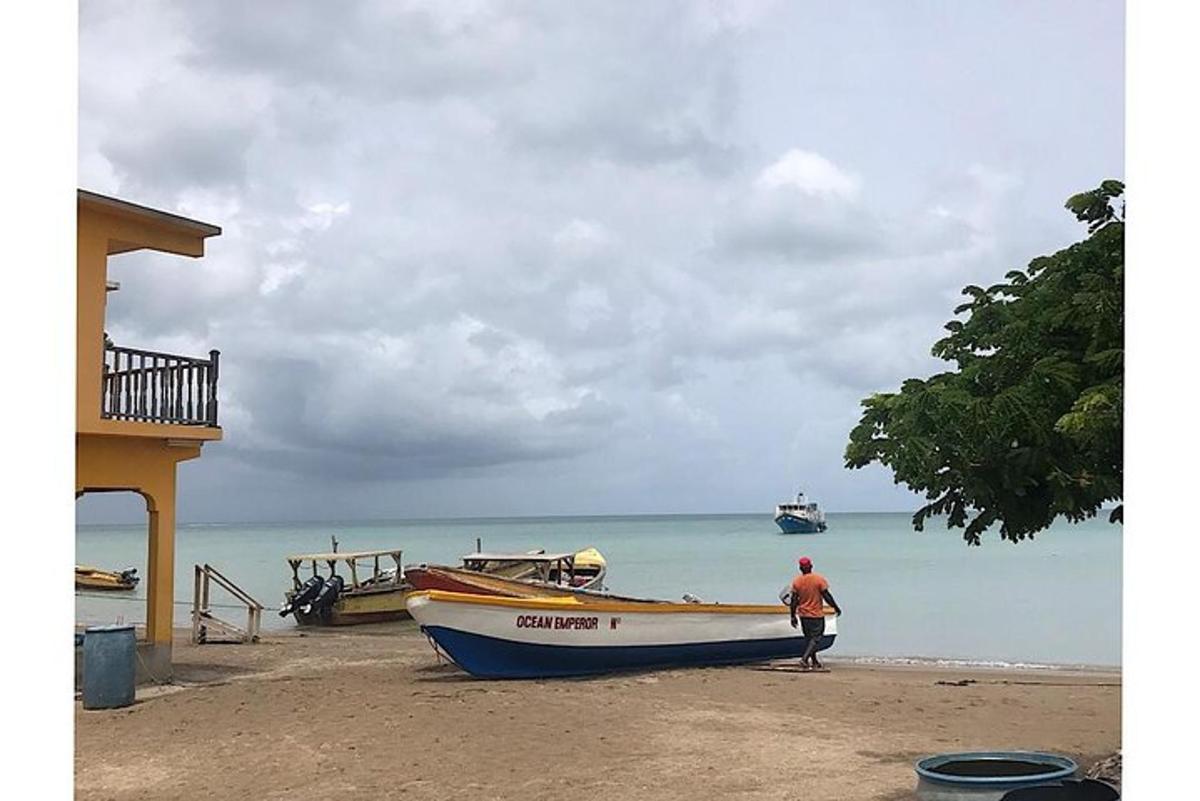 un uomo in piedi accanto a una barca sulla spiaggia