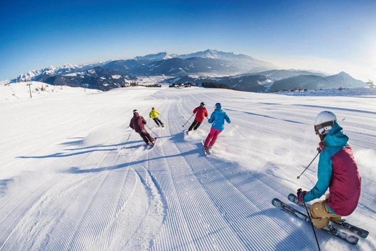 a group of people skiing down a snow covered slope
