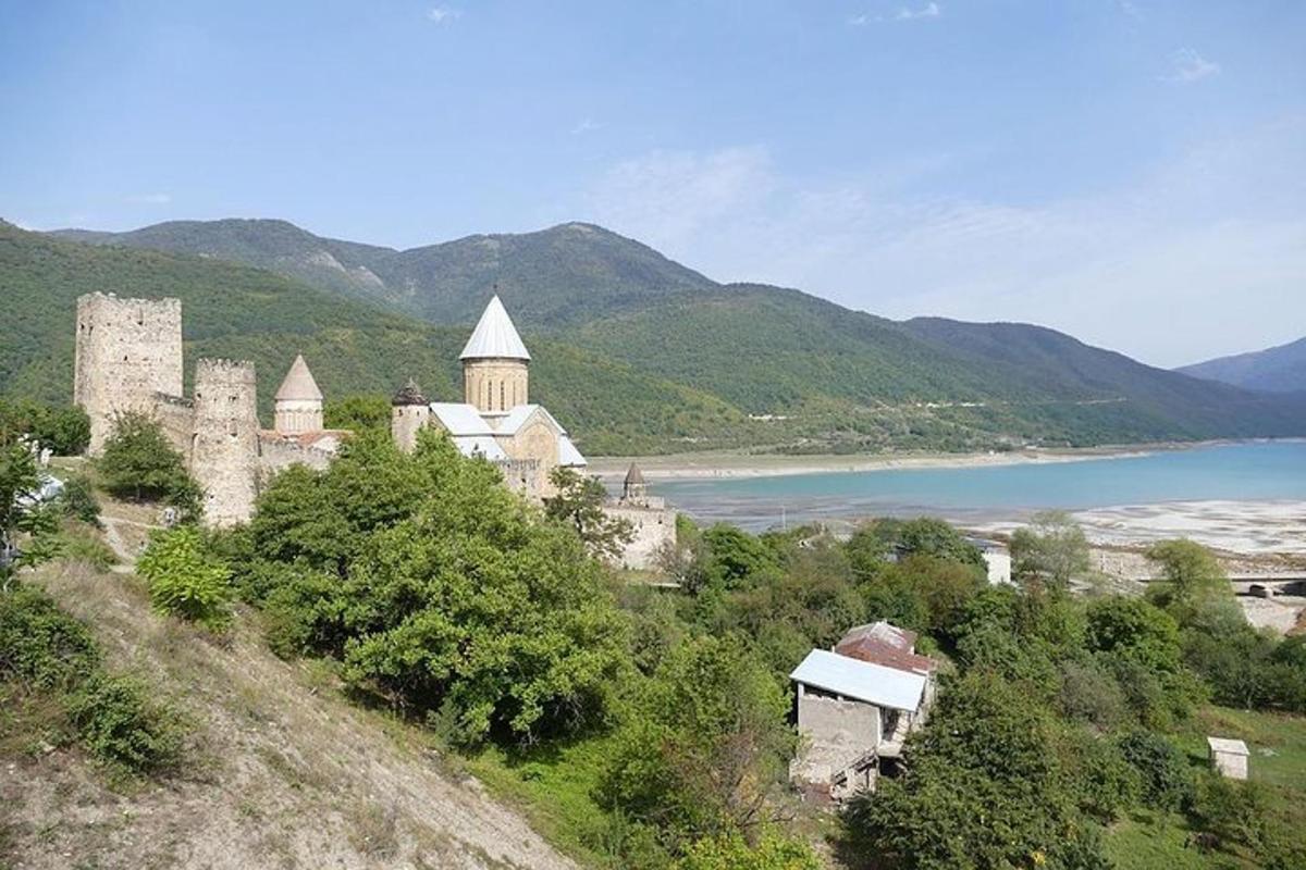 an old castle on a hill next to a body of water