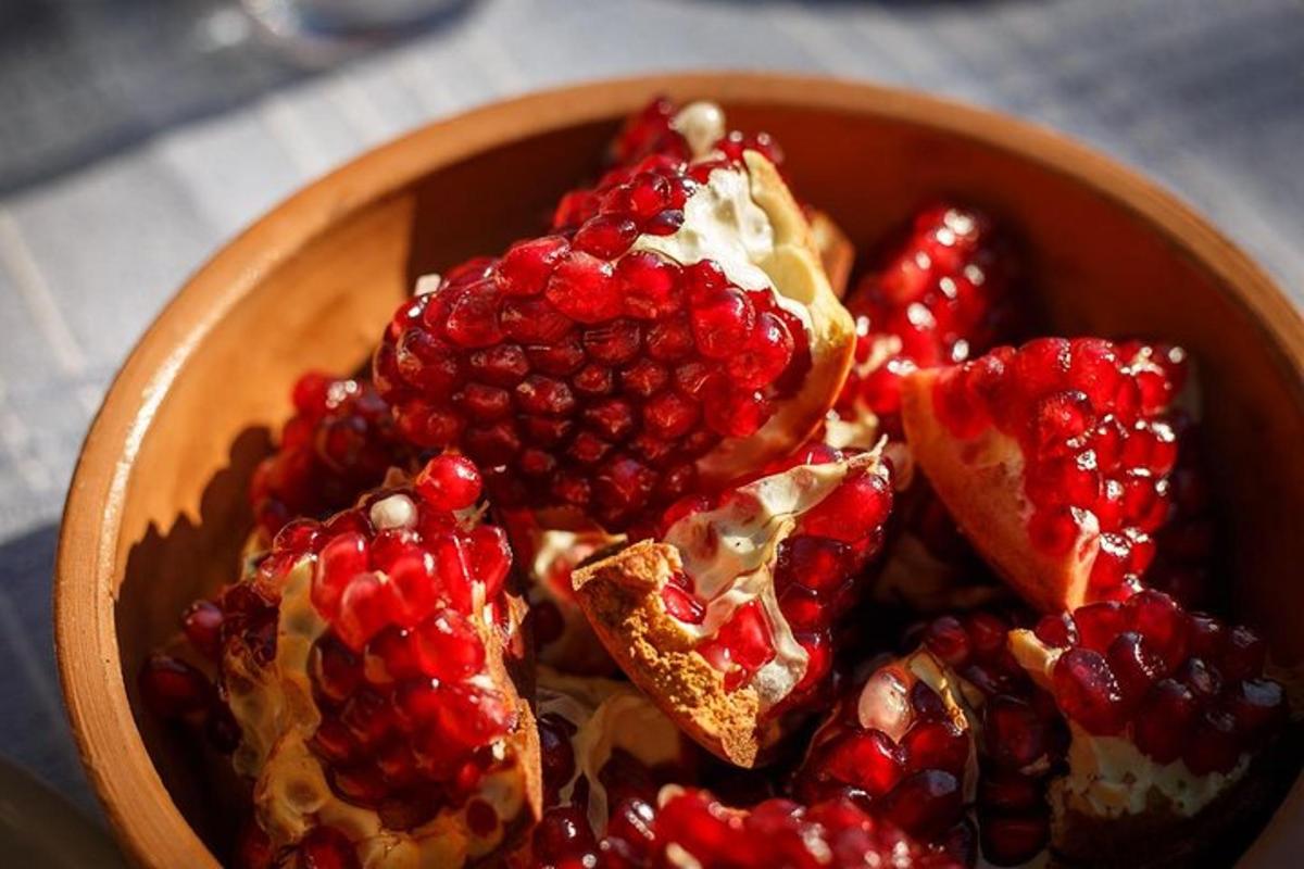 a bowl of food with pomegranates and bread
