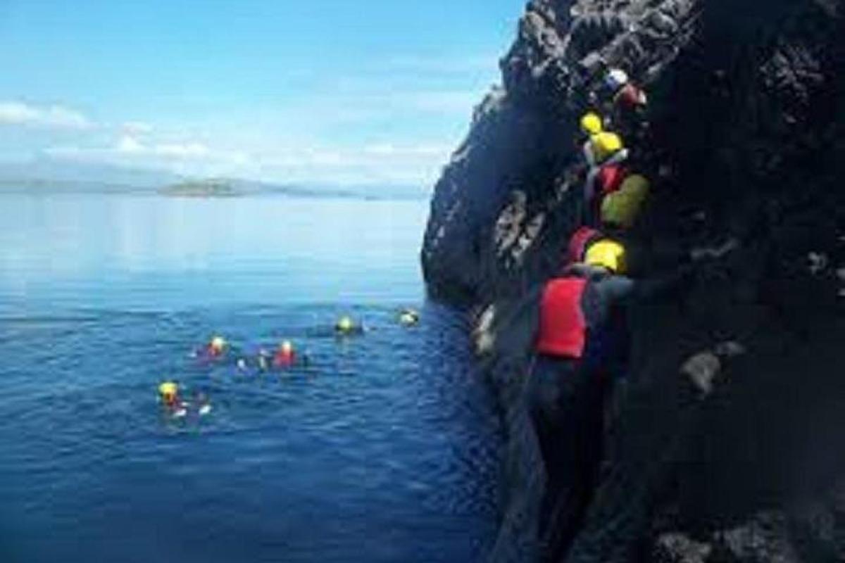 Un grupo de personas trepando una roca en el agua.