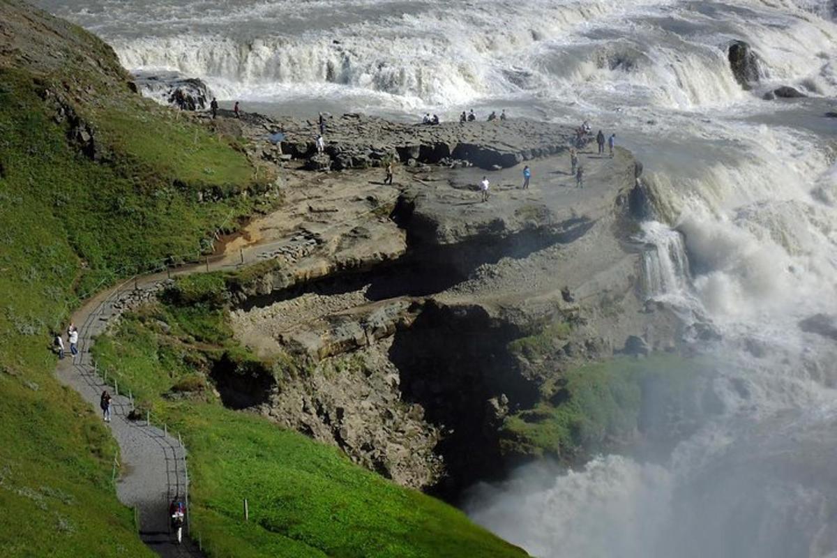 eine Gruppe von Menschen steht am Rand eines Wasserfalls