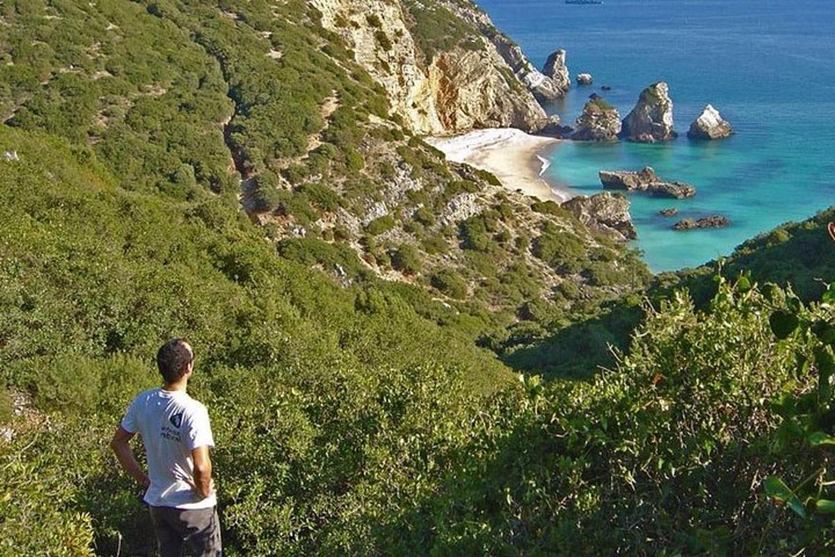 Un hombre parado en una colina mirando el océano.