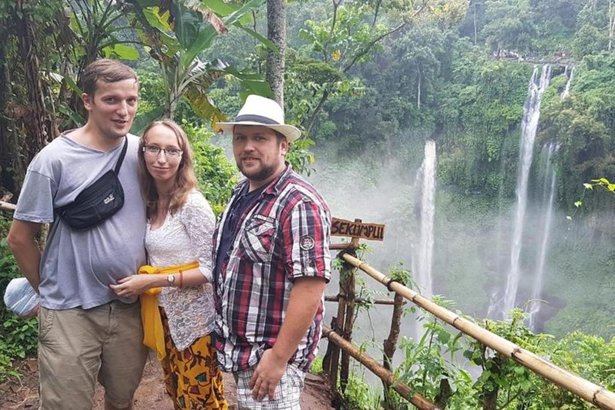 due uomini e una donna in piedi davanti a una cascata