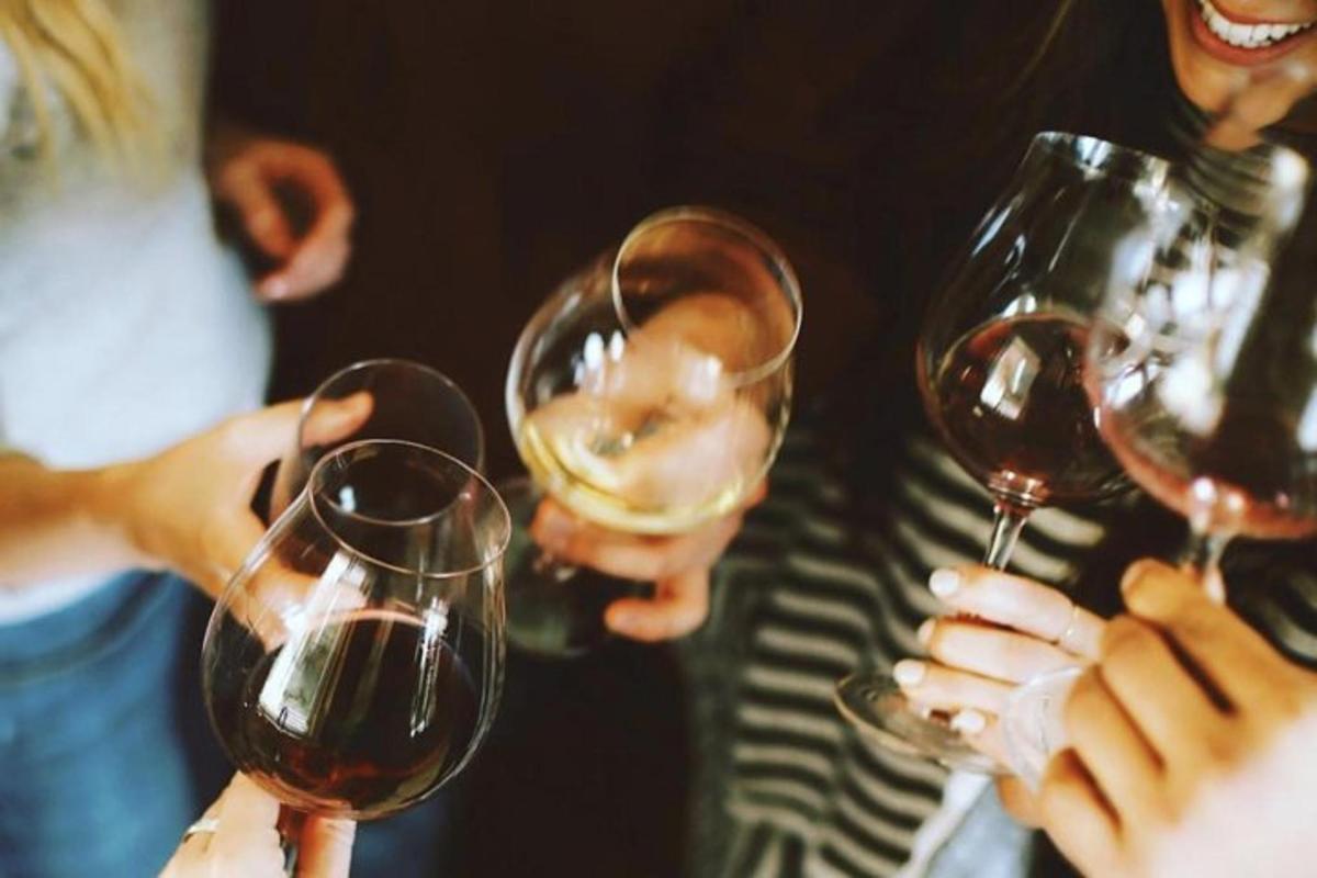 trei persoane care țin pahare de vin în mâini