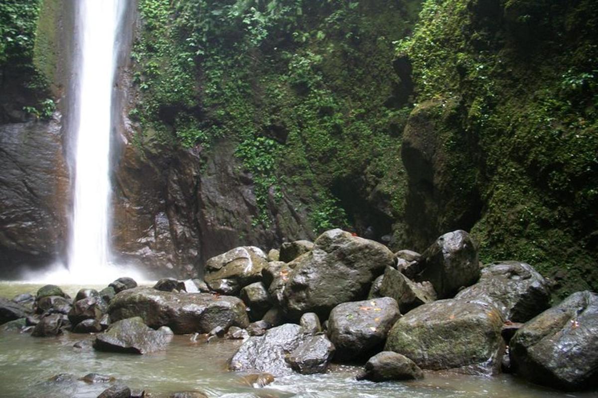 a waterfall and rocks in front of a waterfall