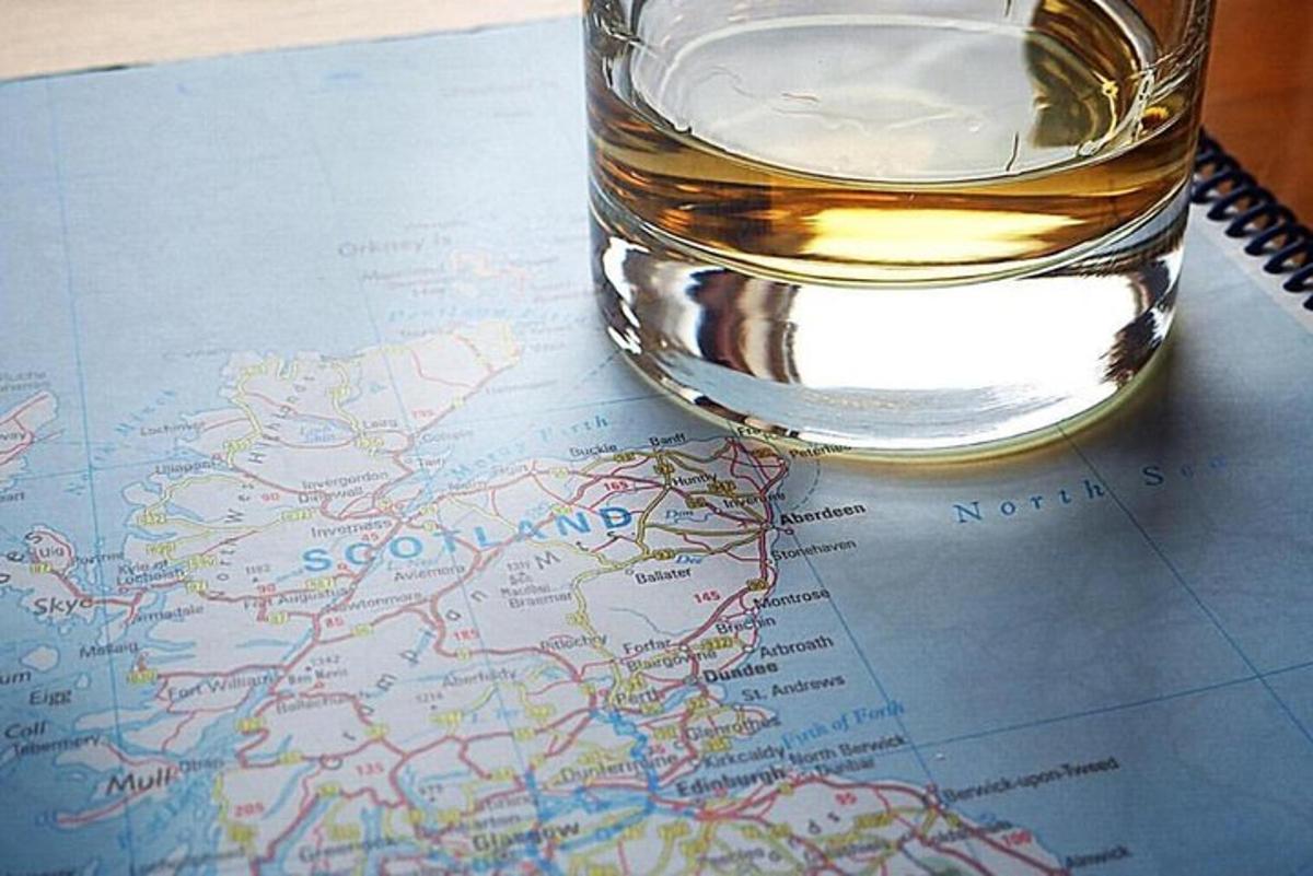 un bicchiere di whisky appoggiato su una mappa