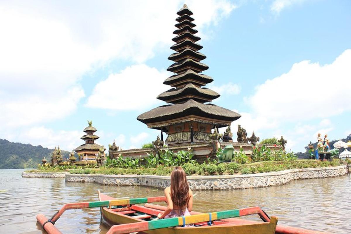 Una mujer en un bote en el agua frente a una pagoda