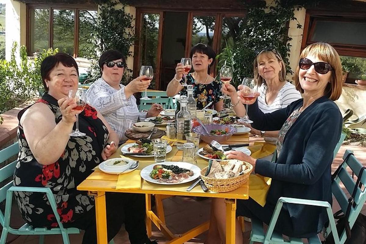 um grupo de pessoas sentadas ao redor de uma mesa bebendo vinho