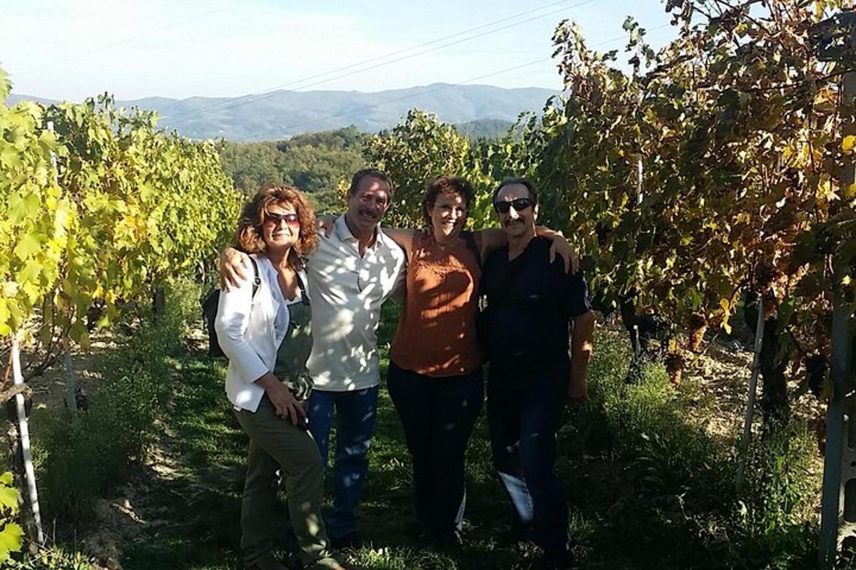 um grupo de pessoas posando para uma foto em um vinhedo