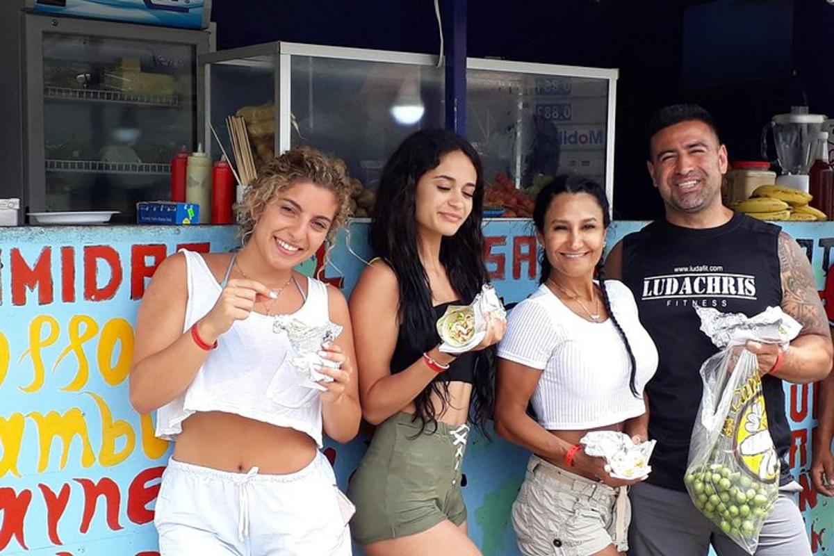un gruppo di persone in piedi davanti a uno stand gastronomico