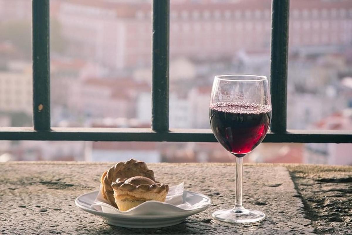 a glass of wine sitting next to a plate of food