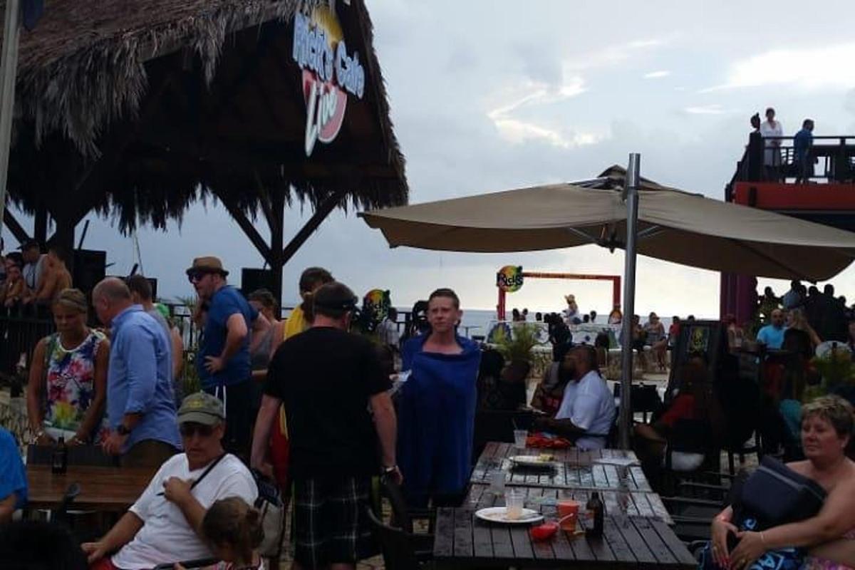 skupina ljudi, ki sedijo za mizami na plaži