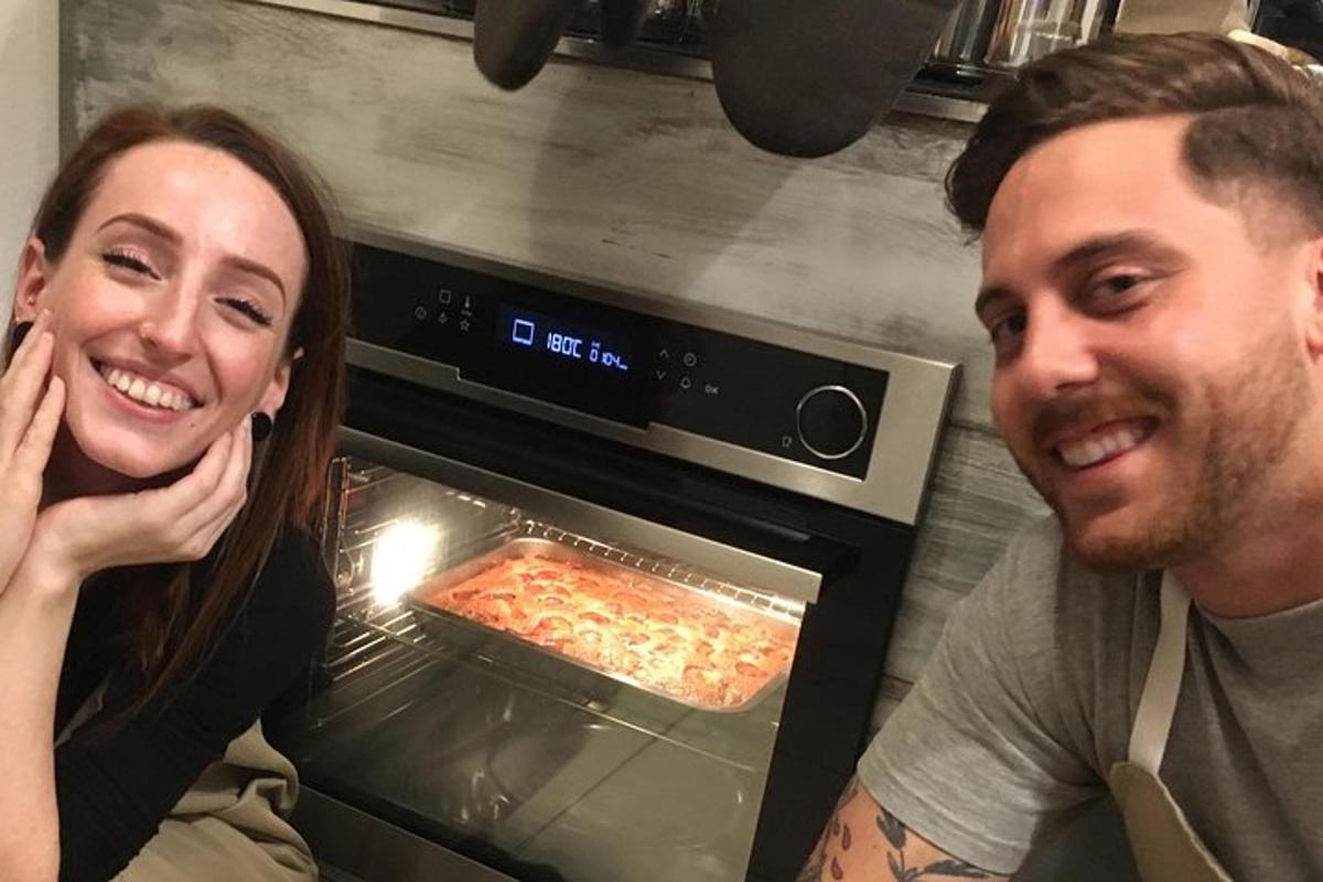 un uomo e una donna in piedi davanti a un forno