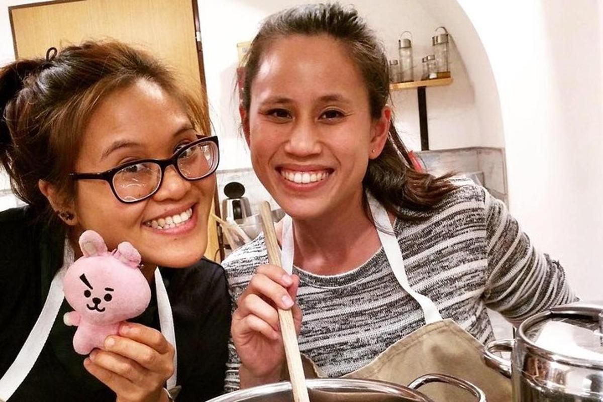 dua wanita duduk di meja dengan anak patung babi