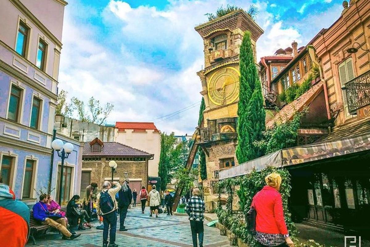 група људи која хода улицом са сат-кулом