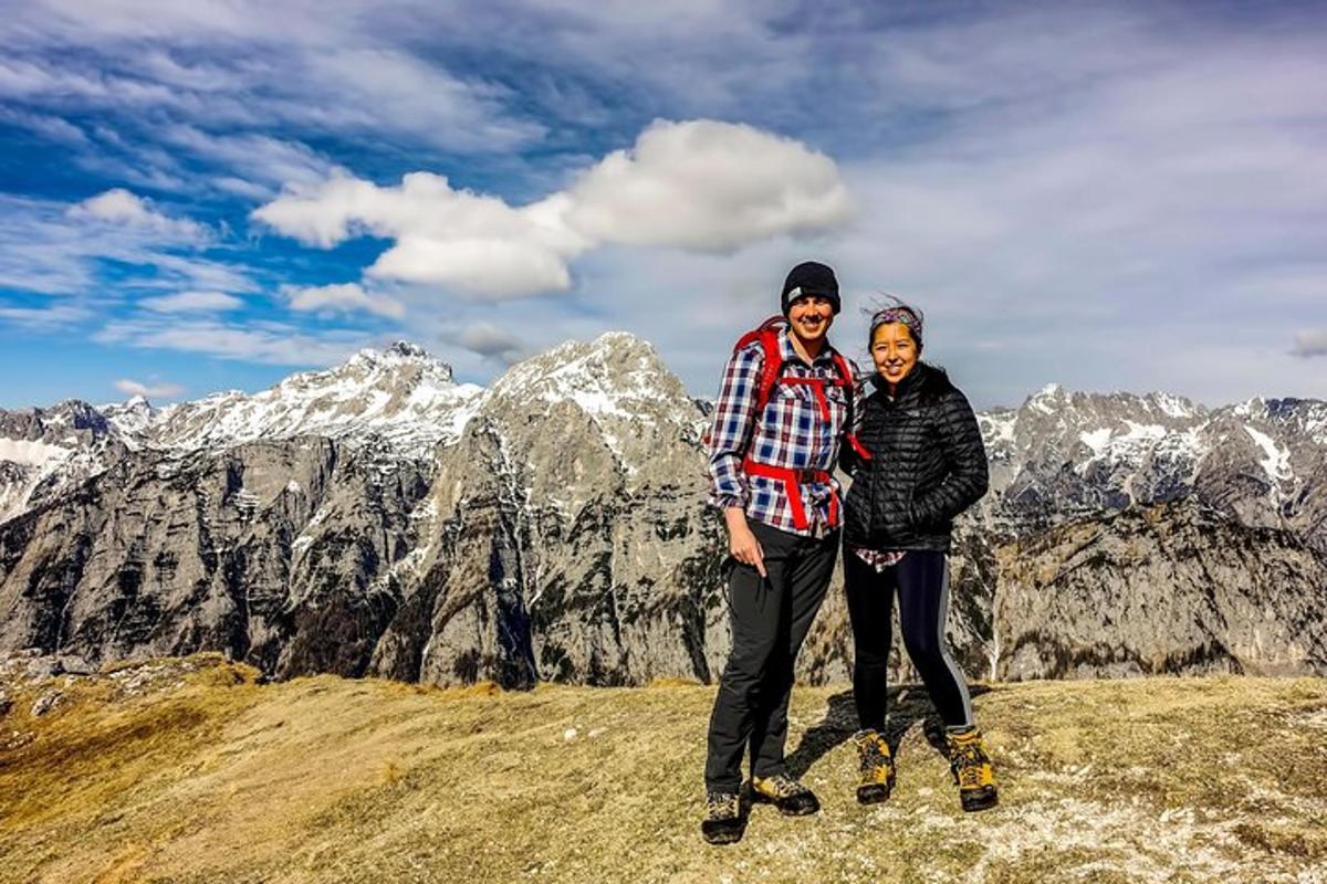 dos personas de pie en la cima de una montaña