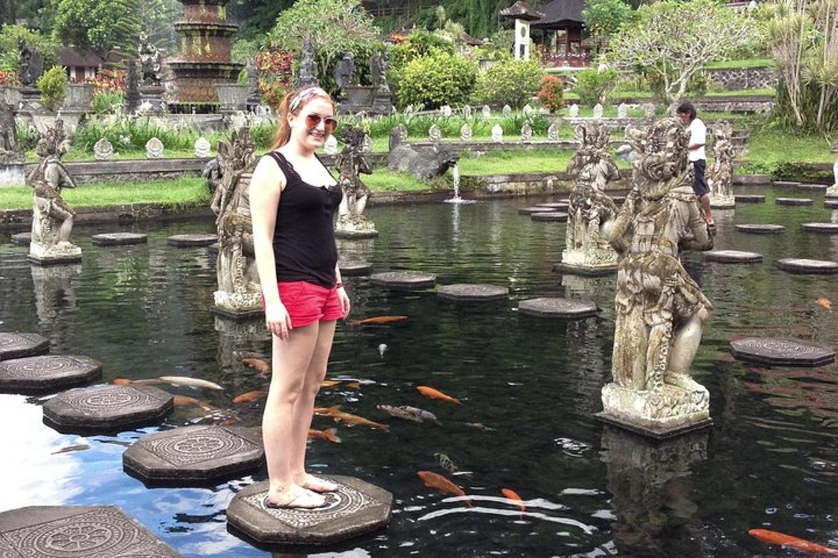 una donna in piedi su una roccia in uno stagno in un giardino