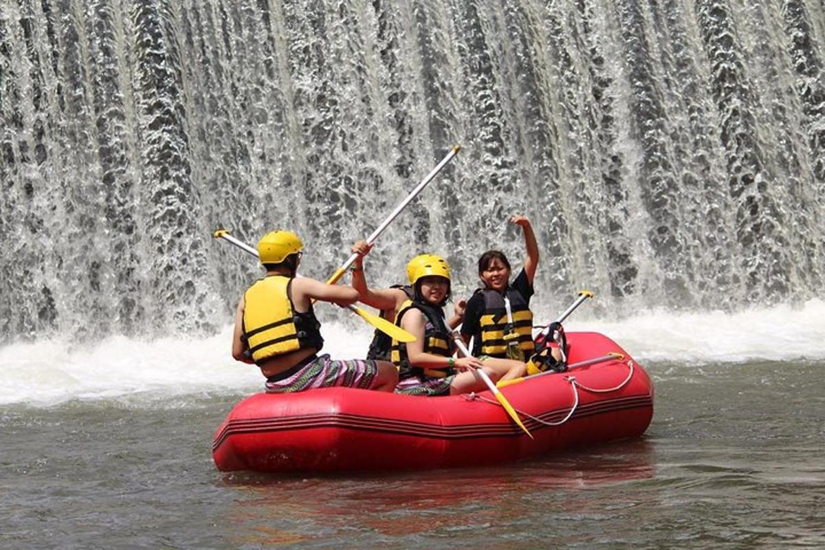 three people on a raft in front of a waterfall