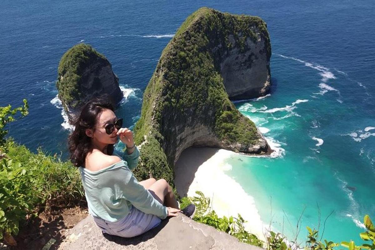 una donna seduta su una roccia vicino all'oceano