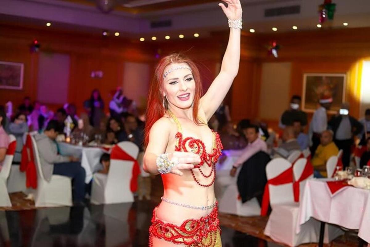 امرأة تقف على حلبة الرقص وذراعها مرفوعة في الهواء