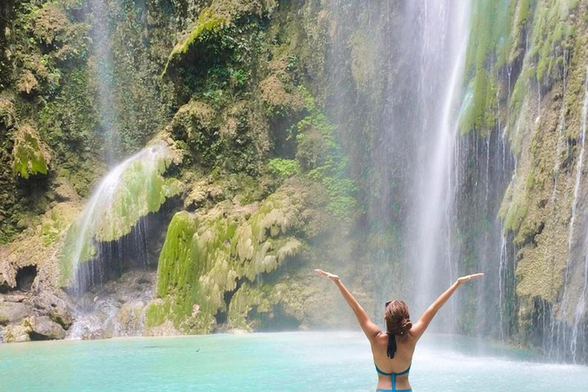 seorang wanita di dalam air di hadapan air terjun