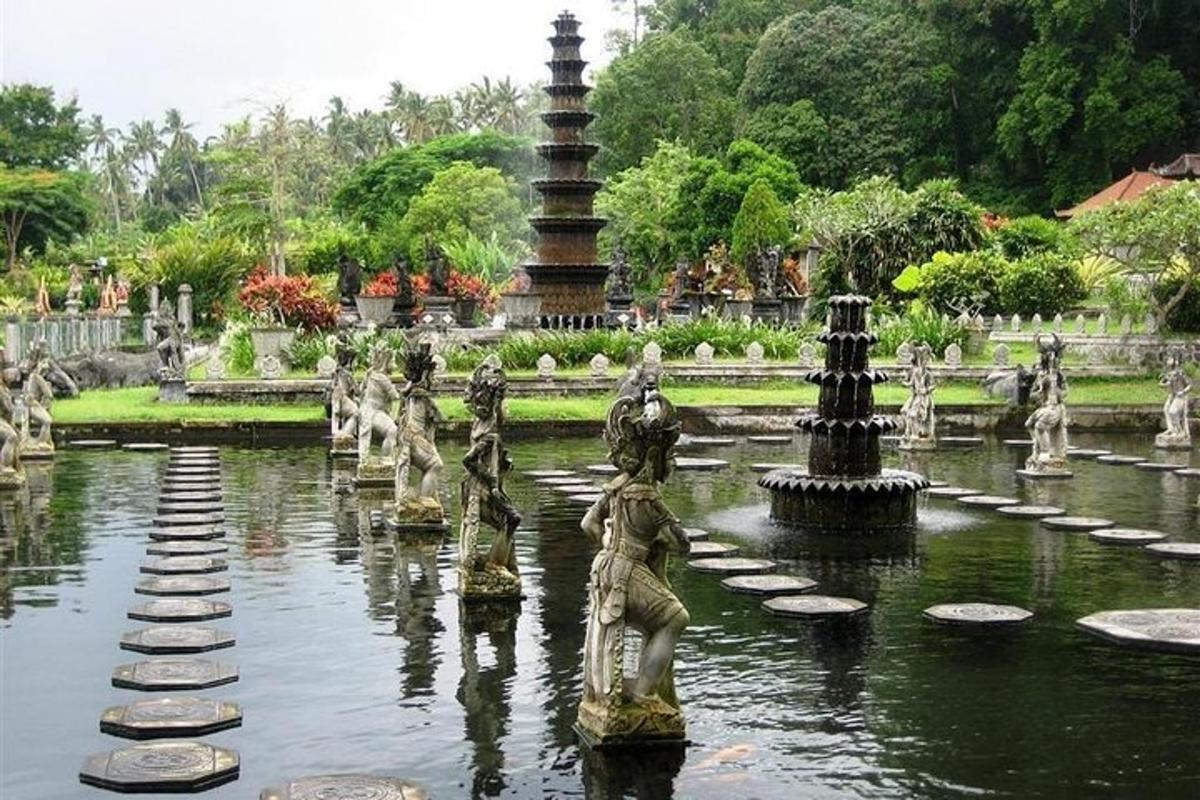 Una fuente en un jardín con estatuas en el agua.