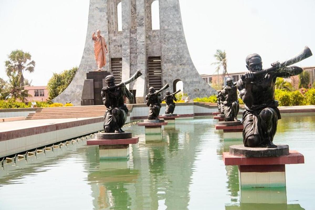 sekelompok patung duduk di air di depan sebuah monumen
