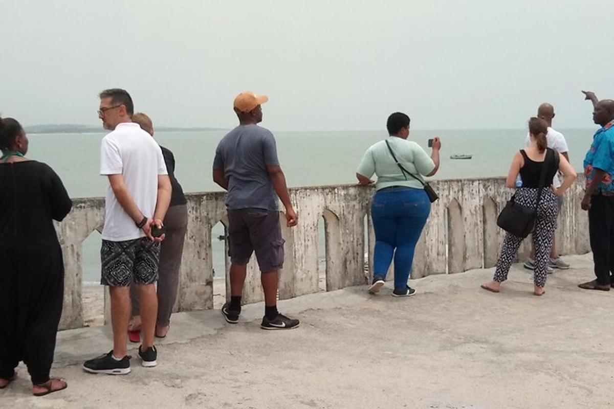 un gruppo di persone in piedi su un muro che guarda l'acqua