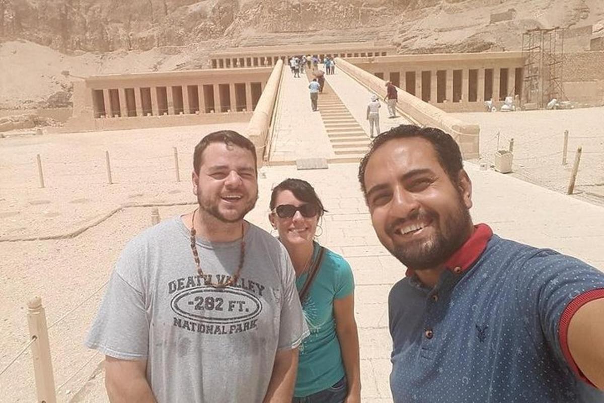 due uomini e una donna in piedi davanti a una piramide
