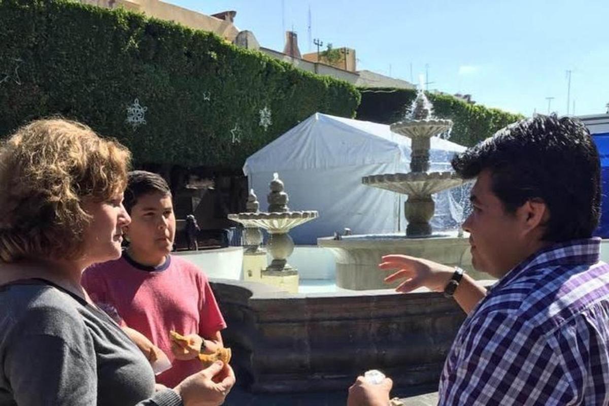 a group of people standing in front of a fountain