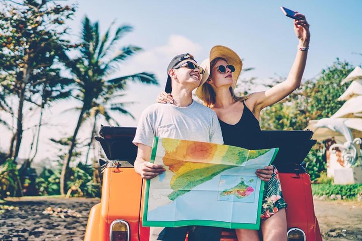 a man and a woman sitting on a car with luggage