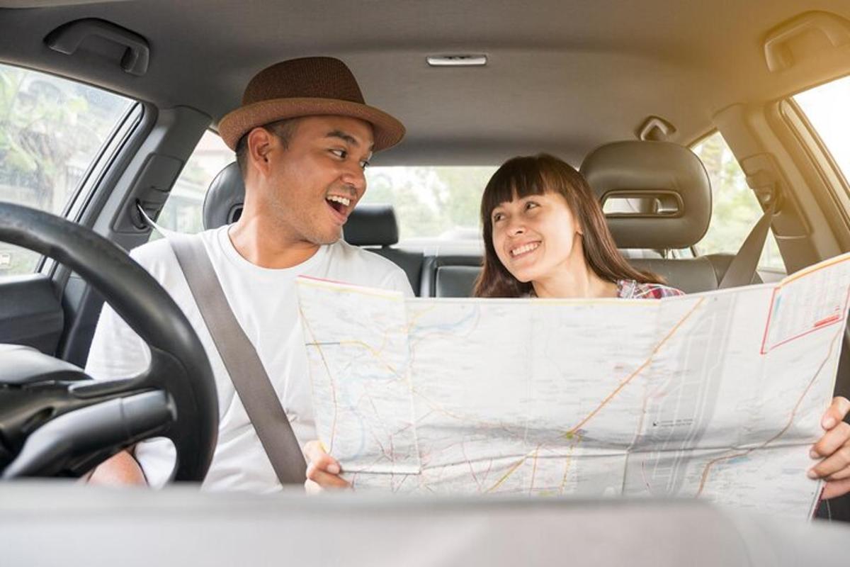 un uomo e una donna seduti in macchina che guardano una mappa