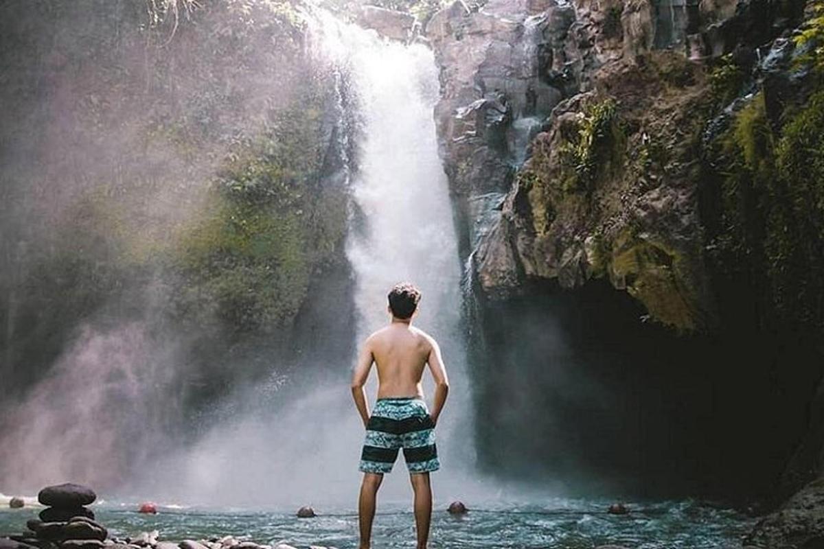 un uomo in piedi davanti a una cascata