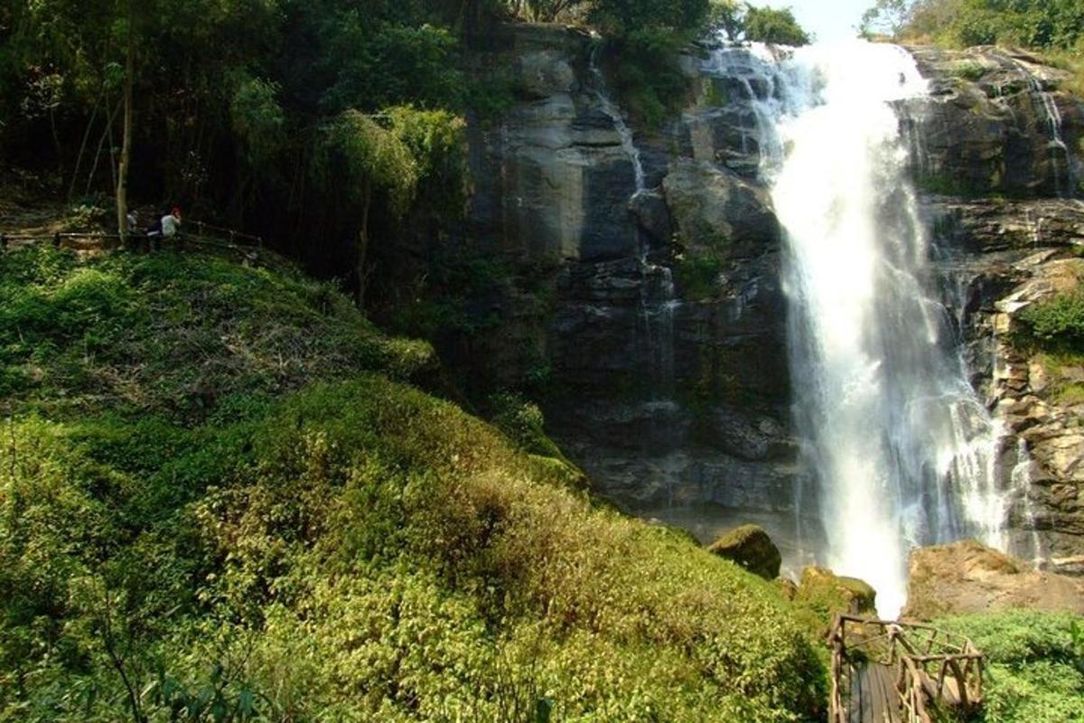 isang talon sa gilid ng isang bundok na may mga taong nakatayo malapit dito