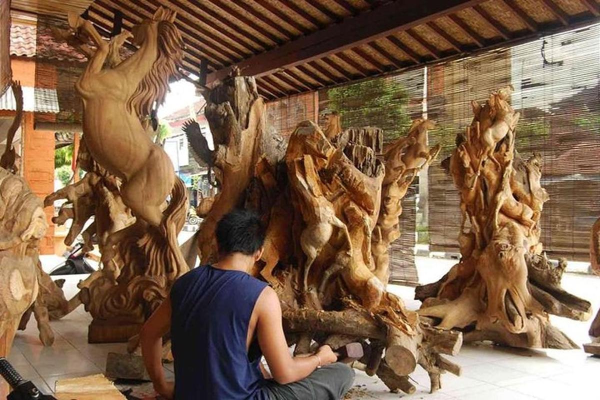 un uomo seduto a terra accanto a una catasta di legna