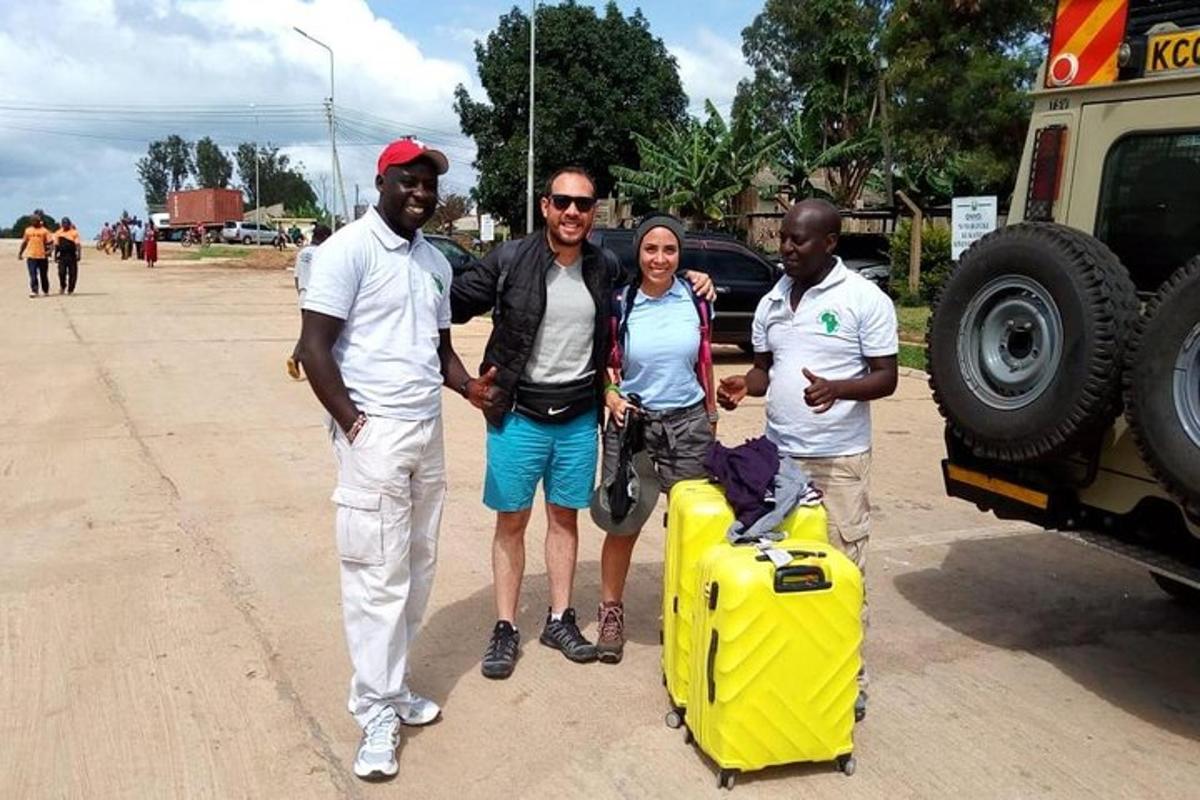 a group of three people standing next to a yellow suitcase