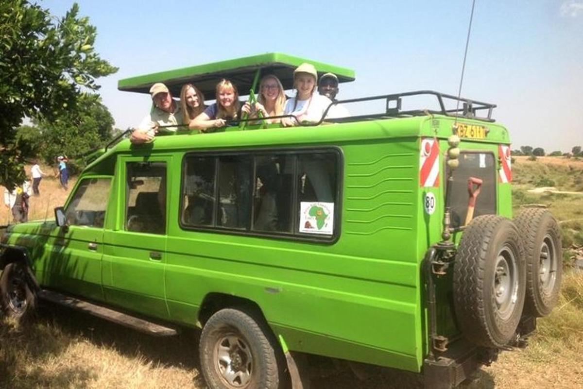 Un grupo de personas viajando en la parte trasera de un jeep verde.
