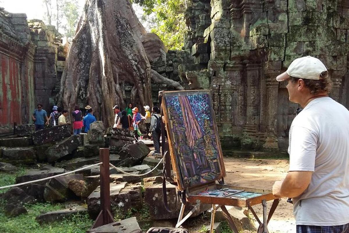 một người đàn ông đứng cạnh giá vẽ với một bức tranh