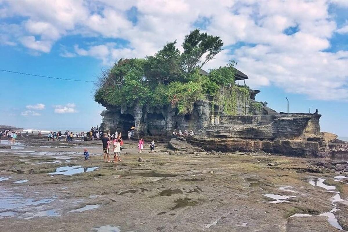 skupina ljudi, ki stojijo na plaži blizu otoka
