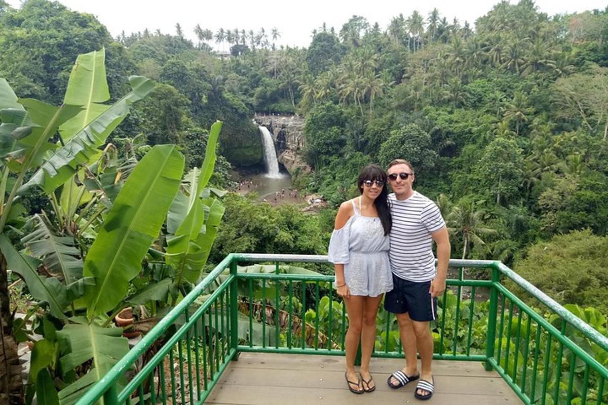 un uomo e una donna in piedi su un ponte di fronte a una cascata