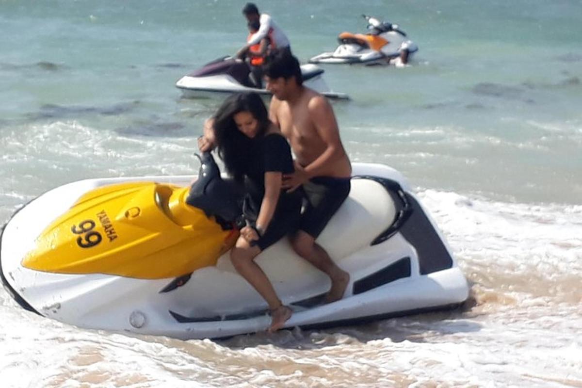 dua orang menaiki jet ski di pantai